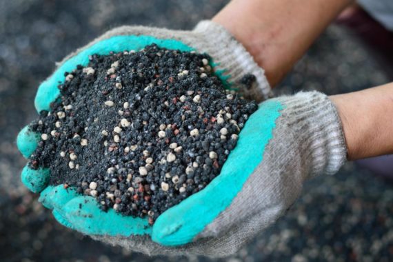 gloved-hands-holding-dirt-and-fertilizer